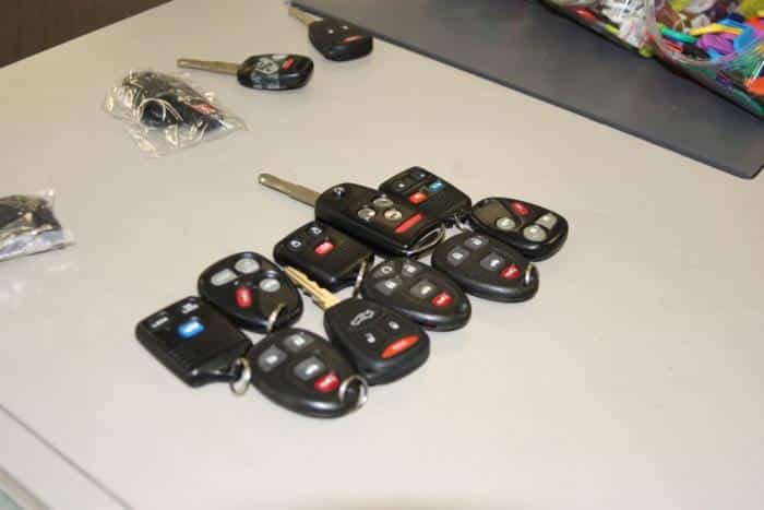 a selection of car key remotes, fobs, and transponder head keys that we cut and programmed