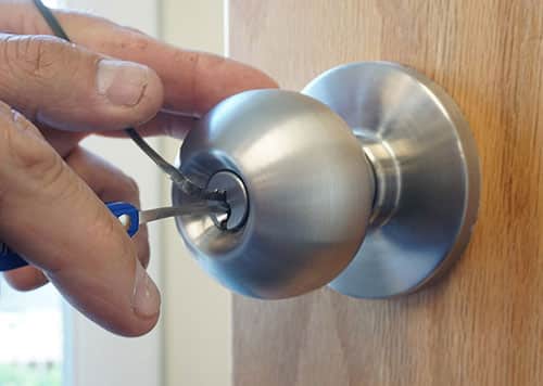 image of a locksmith picking a door lock with professional locksmith tools